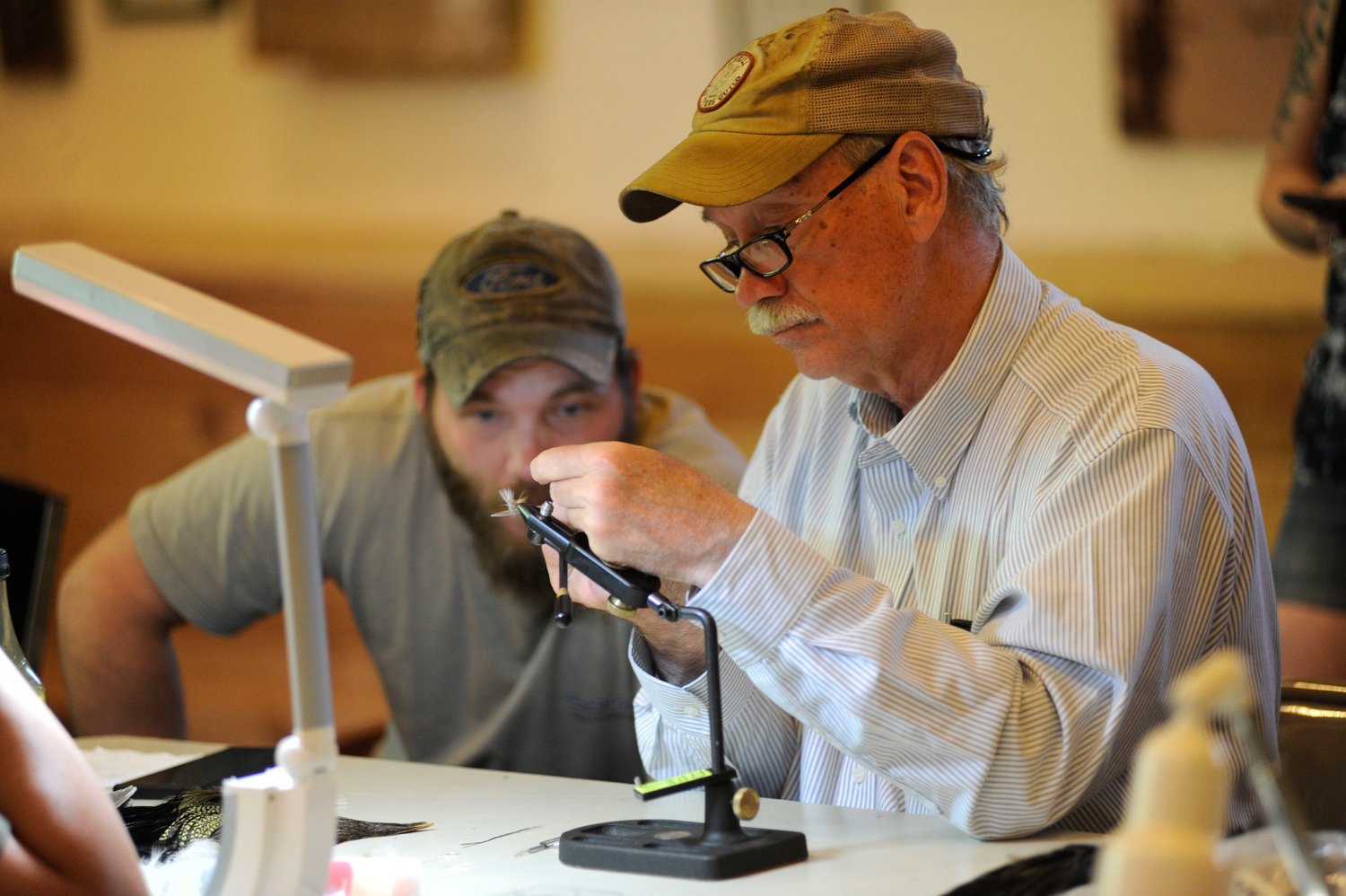 Hands-on teaching. Joseph Ceballos, president of the Catskills Fly Tyers Guild, shows a young tyer a few tricks of the art...
